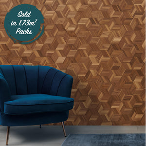 A mixed walnut wood wall design with beautfiul detail. The design includes small strips of 2d walnut arranged in a way to make a cube pattern. In front of the panel is a blue velvet armchair.