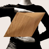 To show the scale a person holding one of the Caro diamond shaped wooden panels at chest height.