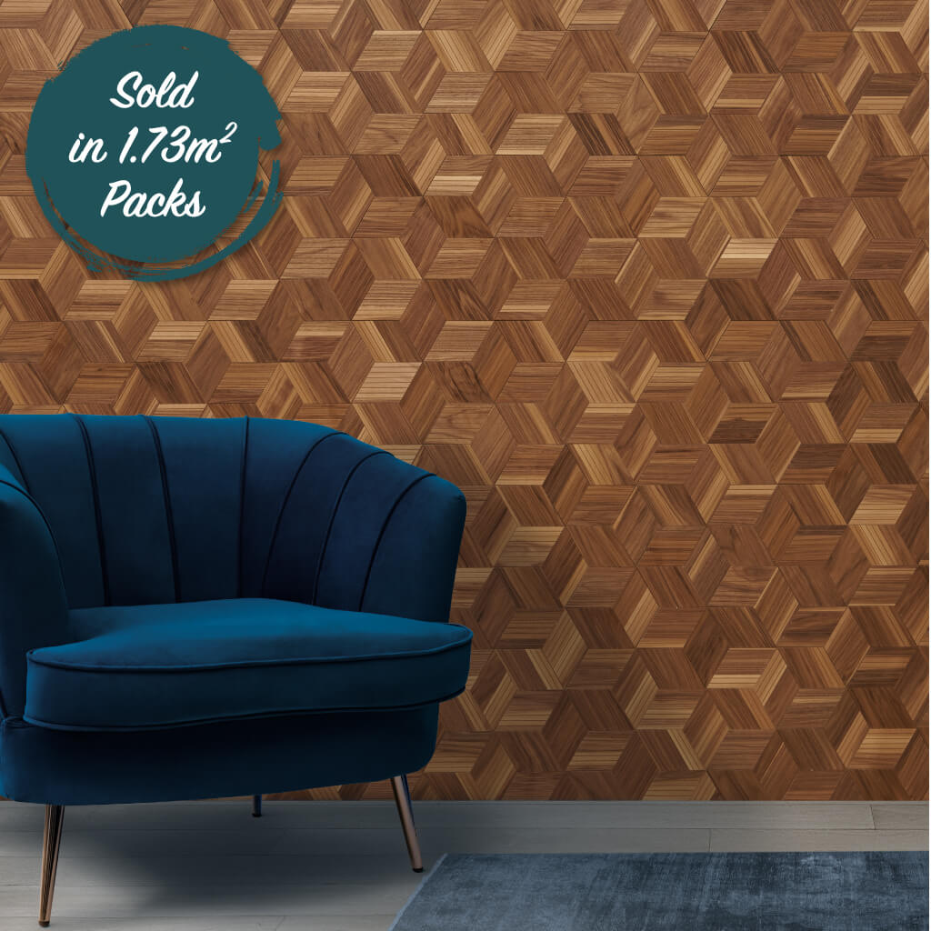 A mixed walnut wood wall design with beautfiul detail. The design includes small strips of 2d walnut arranged in a way to make a cube pattern. In front of the panel is a blue velvet armchair.