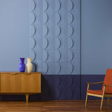 A wall in 2 shades of blue. A section of the wall has a feature created from the Circle wall panels painted in the same blue colours as the wall.