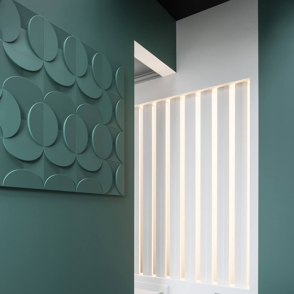 A section of wall with the Circle wall panels. The panels and the wall are both painted a sea green.