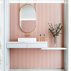 Bathroom with light pink fluted wall panels behind the basin and mirror.