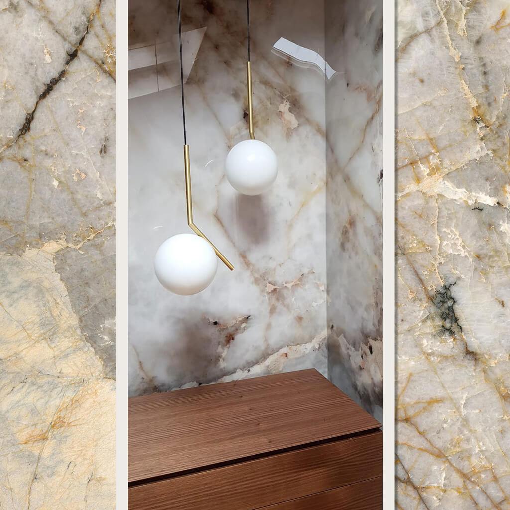 The Hiva marble effect wall panel installed in a corner of a room with gold and white ceiling lights to match the Hiva design.