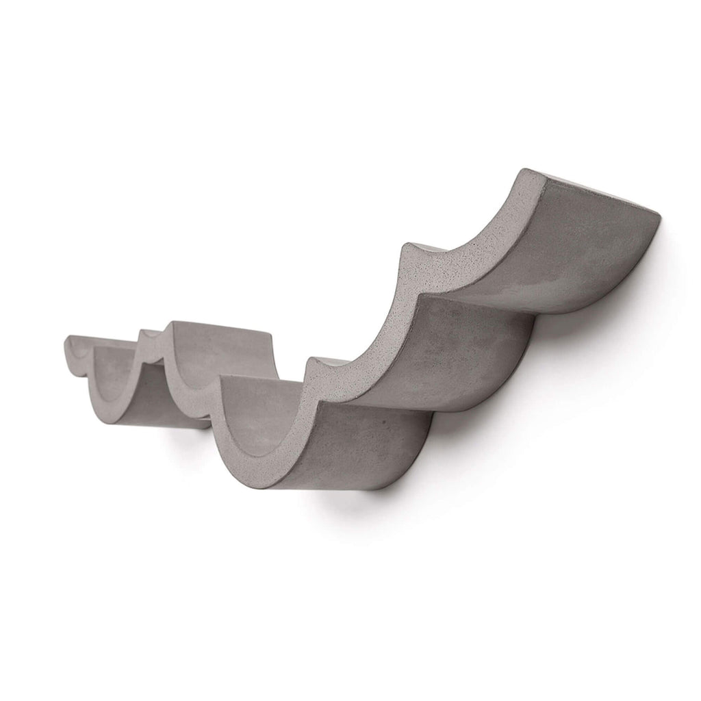 A large thick wall hanging concrete toilet roll holder. The base is a curved for the toilet rolls to fit within the curves.