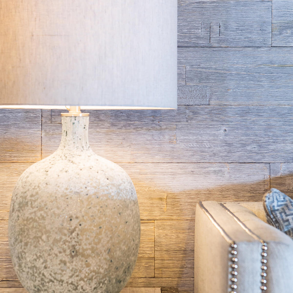 Easily applied wood wall panelling in a living room. The wood grain highlighted by a table lamp