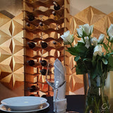Large  freestanding natural wood wine rack with bottles in front of a 3D wood feature wall
