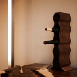 5 tier walnut wood wine rack on a bronze metal base, with 2 bottle os wine and sat on a table