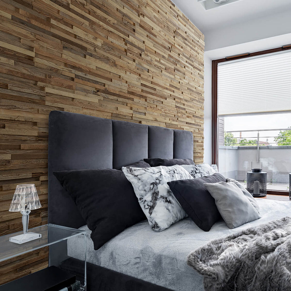 An image of a bedroom where behind the king sized bed and grey headboard is our 3D reclaimed wood wall panels. 