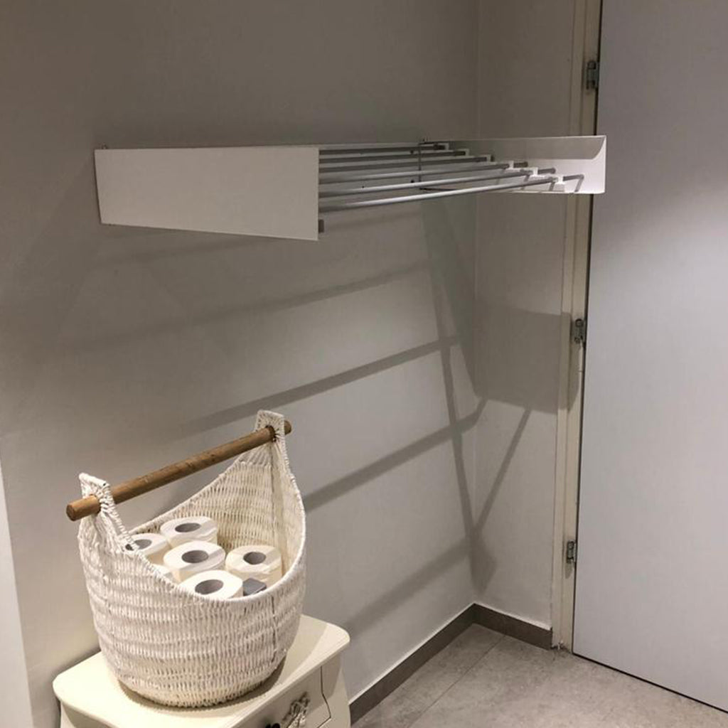 The white wall mounted airer is installed within a laundry room.